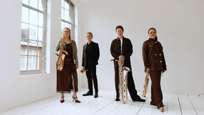 Saxofoonkwartet in een strakke witte ruimte met mooie hoge ronde ramen