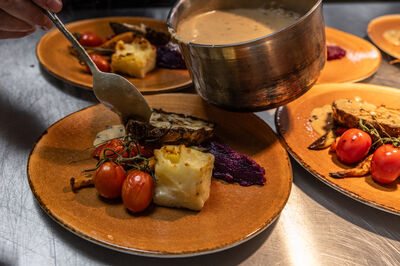 De borden van het theaterdiner worden opgemaakt in de keuken. Gemaakt op het moment dat de saus over het gerecht gaat.