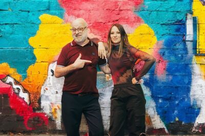 Anton Goudsmit wijzend naar Cato van Dycke voor een gekleurde muur