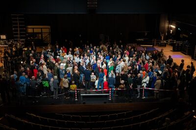 Vrienden staan op het toneel van de grote zaal