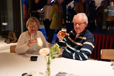 Twee bezoekers/vrienden toasten op de avond