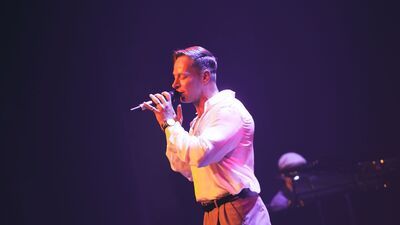 Zanger zingt met ogen dicht en microfoon in zijn hand