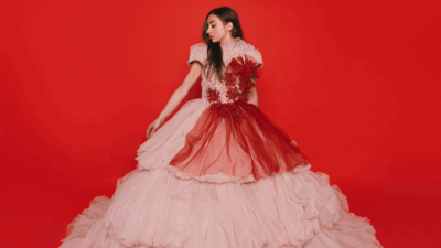 Nona voor een rode achtergrond met prachtige jurk aan