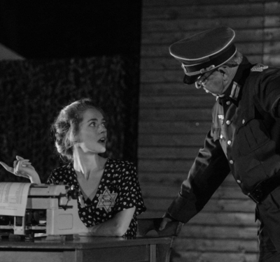 scene uit de voorstelling_ vrouw achter typemacine in gesprek met man in uniform