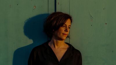 Triest ogende vrouw tegen een groene wand