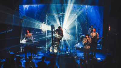 Remy van Kesteren op podium met twee andere muzikanten