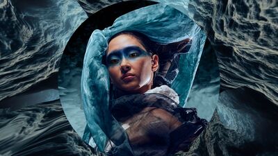 Vrouw tussen water, met blauwe oogmake-up waarvan het gezicht in een soort cirkel is geplaatst
